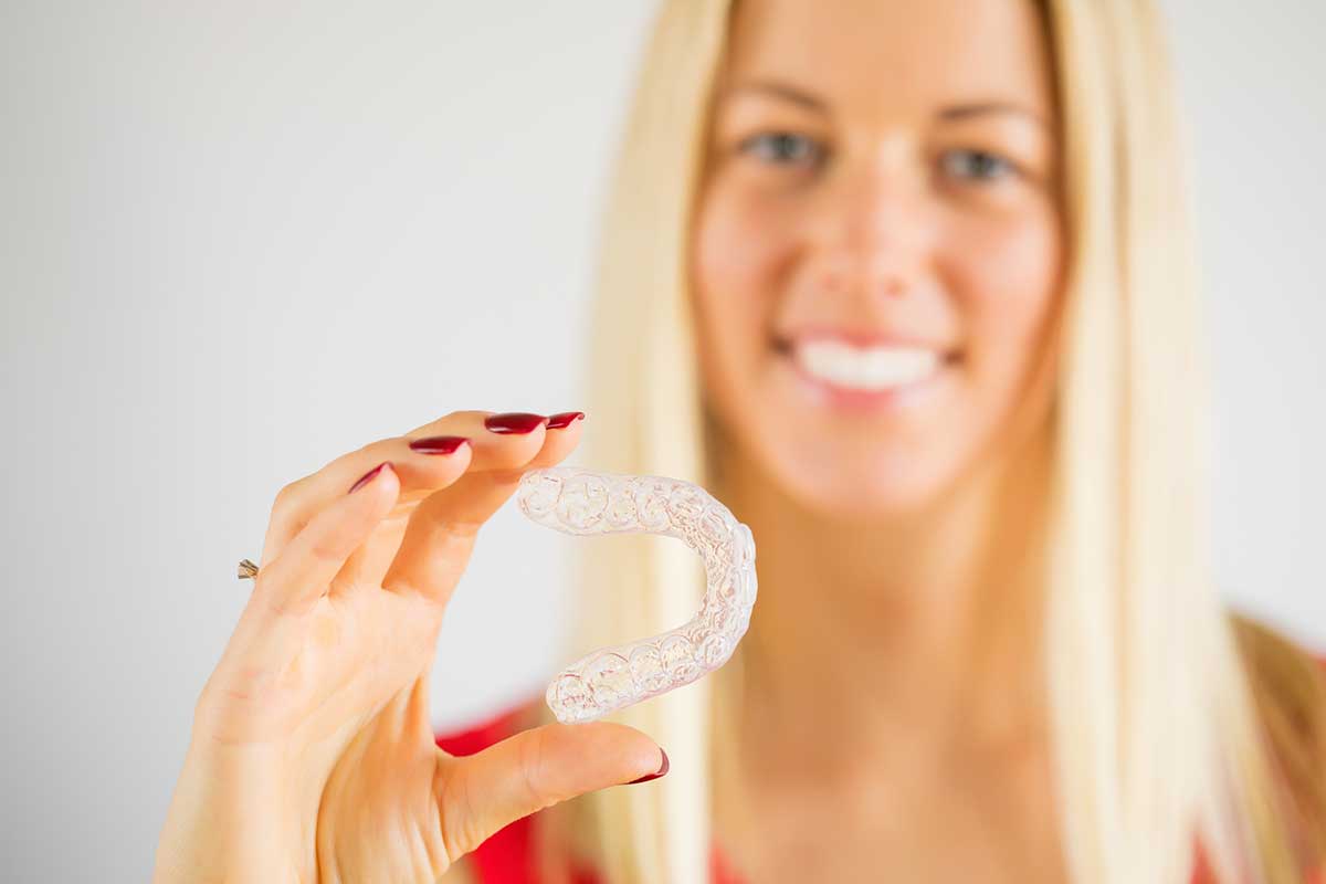 Woman holding teeth whitening tray
